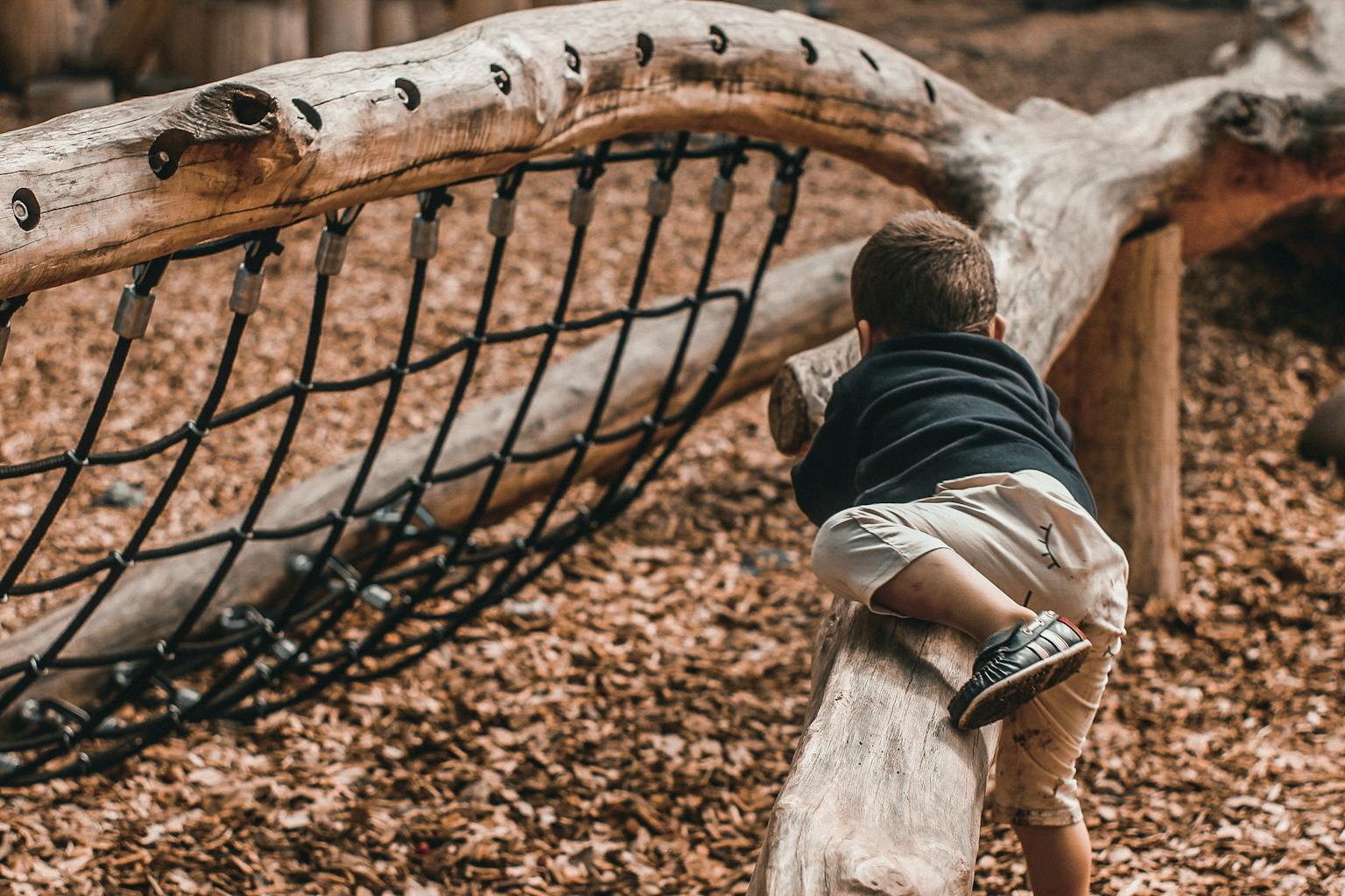Kind klettert auf einem Spielplatz